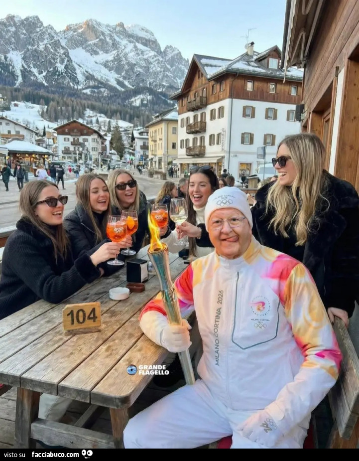 Massimo boldi fiamma olimpica attorniato da ragazze