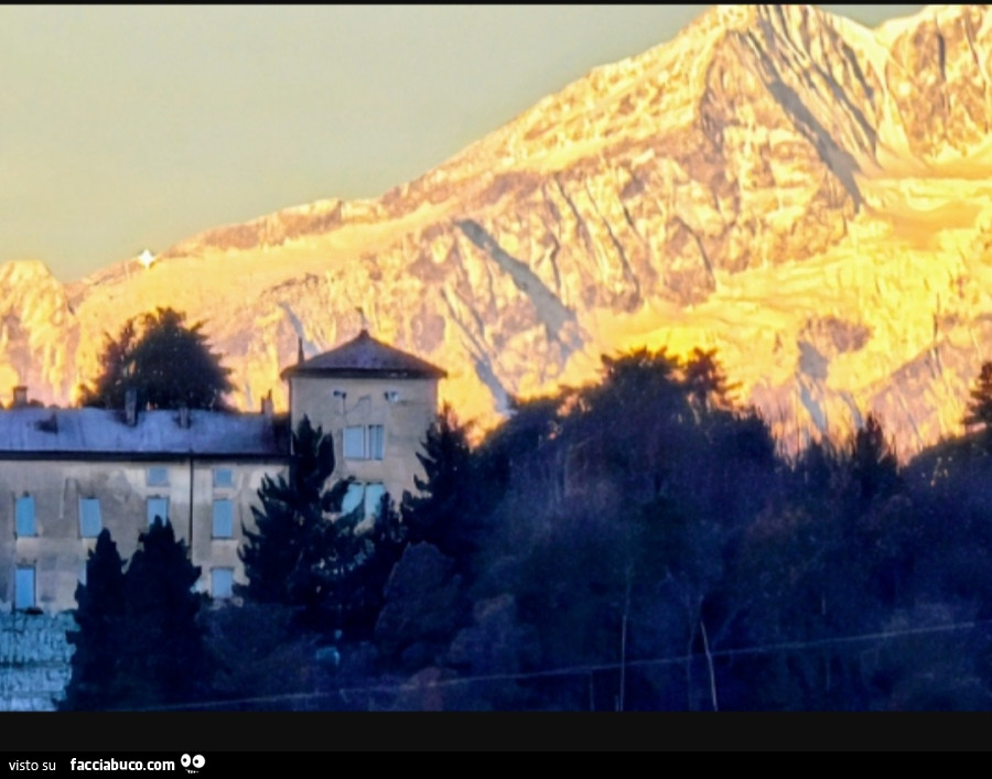 Fotografia dell'alba sul Monte Rosa con luccichio. Si vede anche il Castello Confalonieri. Foto presa dal Varesotto